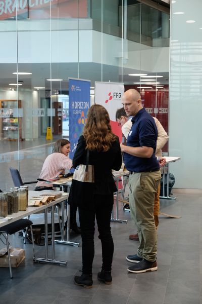 Menschen unterhalten sich bei Informationsständen