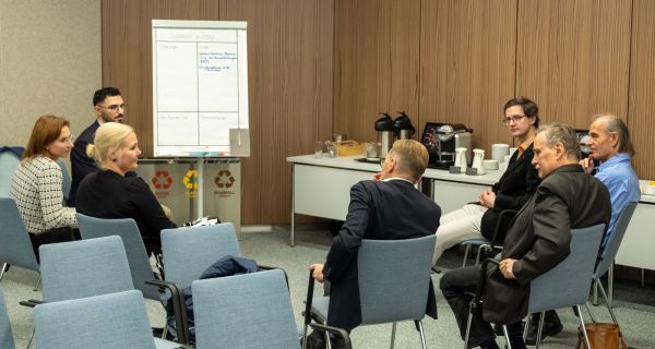 Frauen und Männer beim Austausch in Kleingruppen mit Flipchart