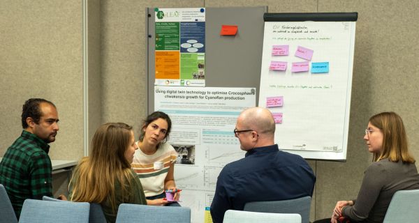 Frauen und Männer beim Austausch in Kleingruppen mit Flipchart